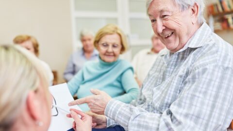 Ein älterer Mann lässt sich in einem Pflegeheim beraten